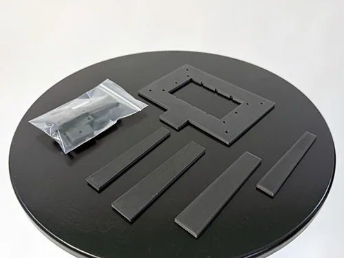 Täpselt 3D-prinditud mustad väikedetailid väiketootmise partiina