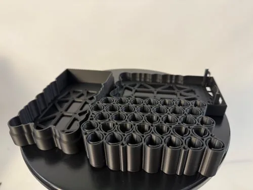 Mustast plastikust 3D-prinditud tööstuslik prototüüp torupesadega – kiirprototüüpimise näide Eestis
